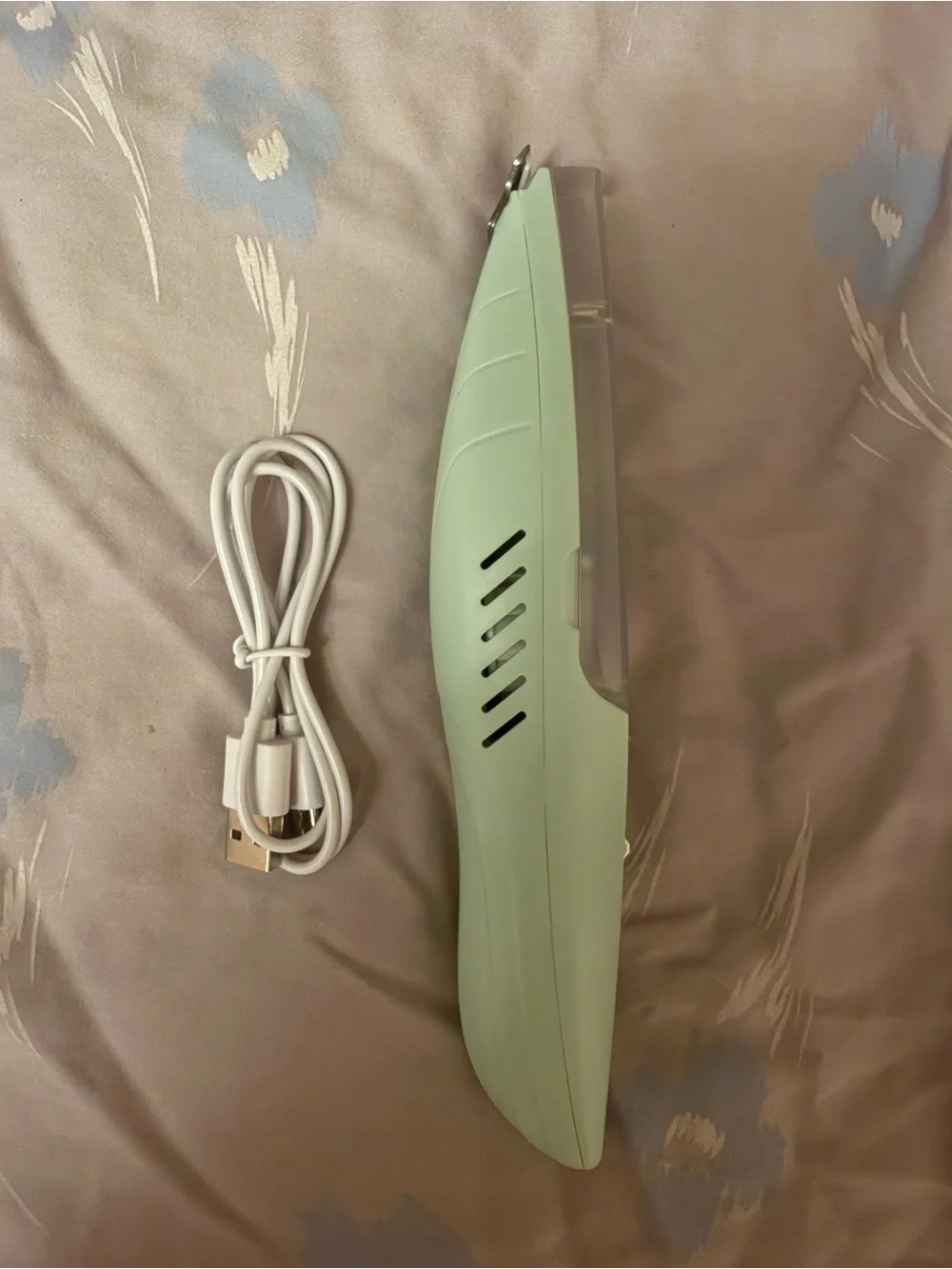 This a green electric pet shaver designed for trimming hair on dogs and cats.